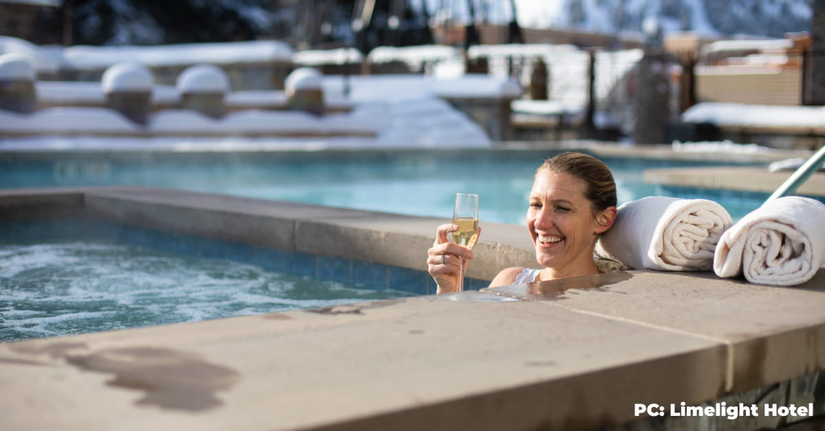 A woman drinking champagne in a hot tub